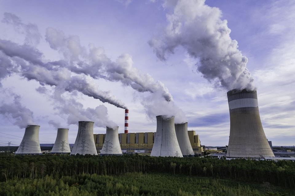 A nuclear power plant's cooling towers are spewing steam.