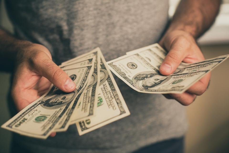 A person counting $100 bills.
